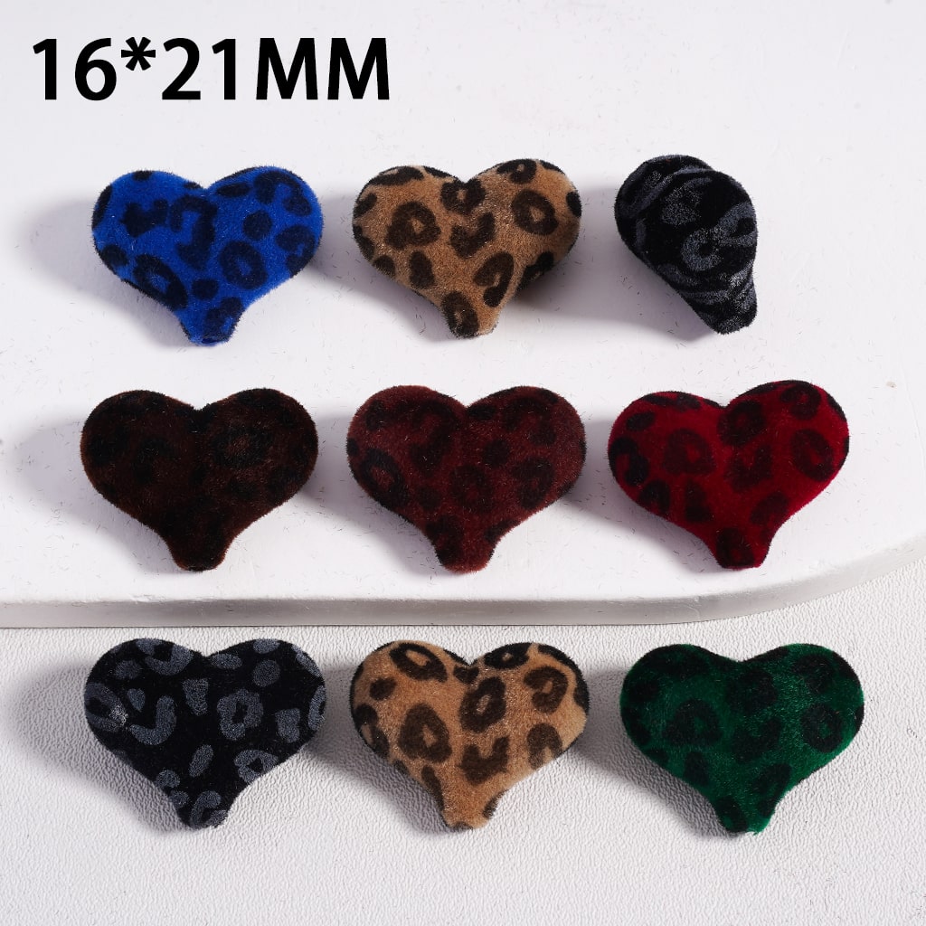 Heart-shaped buttons with leopard print pattern in various colors on a white background.