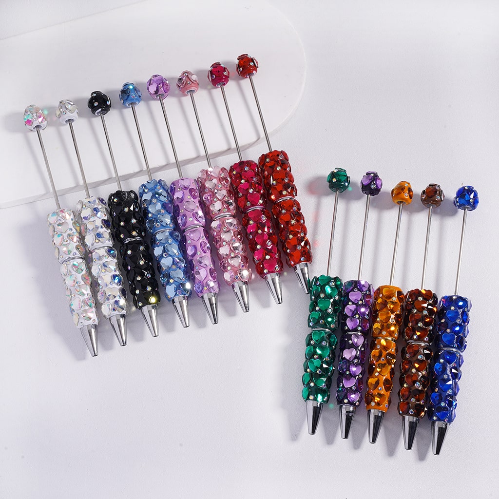 Set of colorful beaded pen toppers on a white background