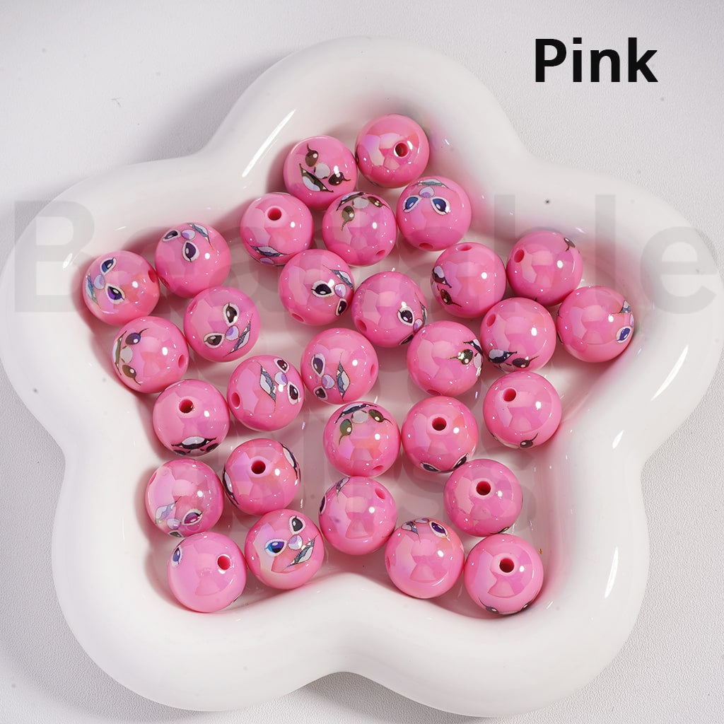 Pink beads with smiley face designs on a white dish