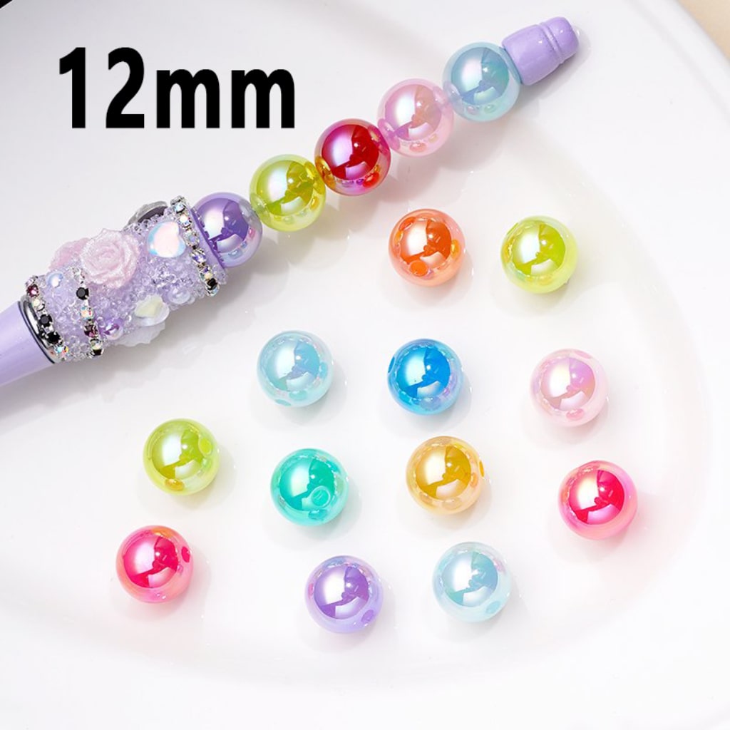 A collection of glossy colorful UV coating shiny round acrylic beads in various colors, with a focus on multicolor beads, displayed on a white surface with a beable pen.