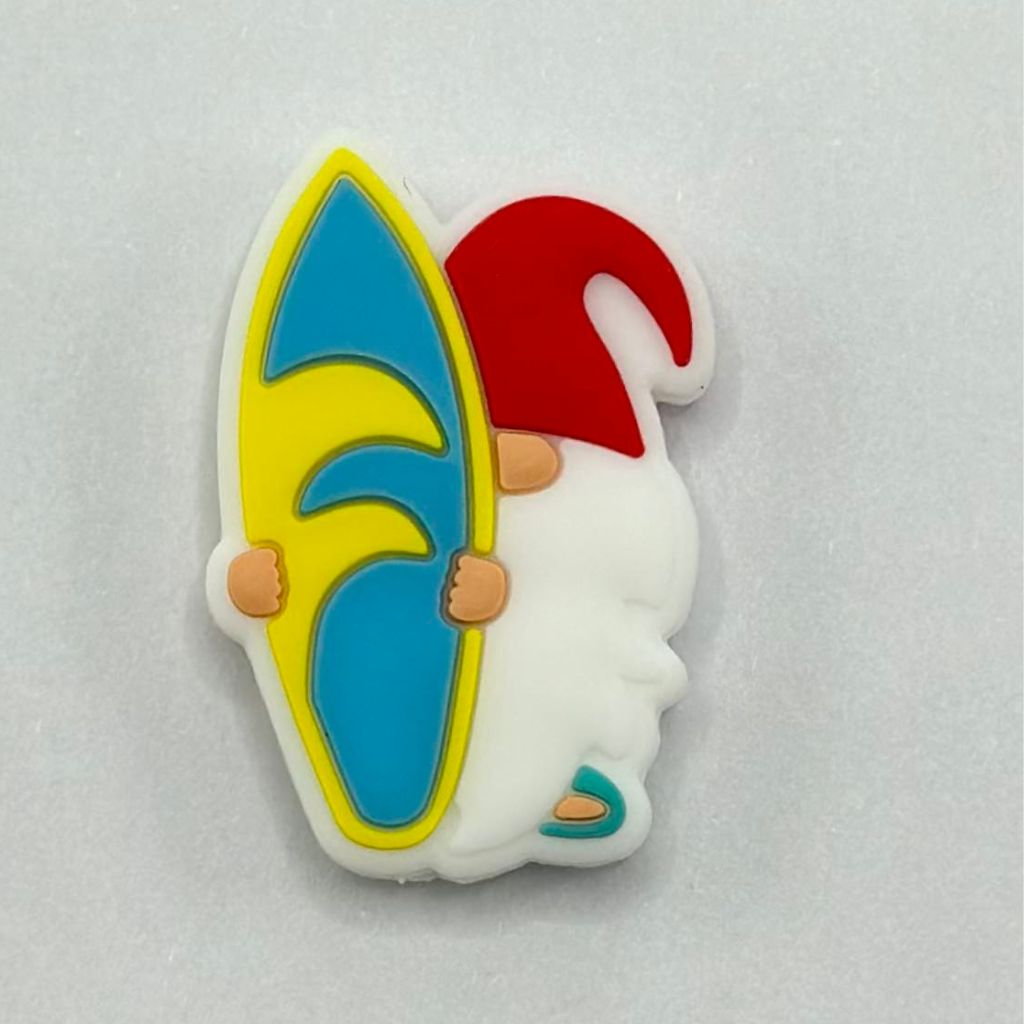 A silicone bead in the shape of a gnome with a surfboard.