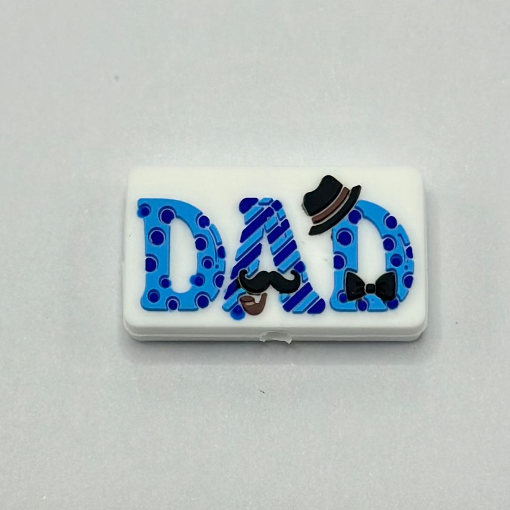 A blue silicone bead with the text 'DAD' written on it, adorned with a mustache, hat, and bowtie.