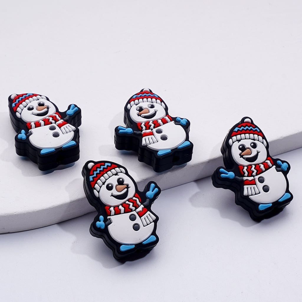 Four snowman-shaped pins with colorful hats and scarves on a white surface.
