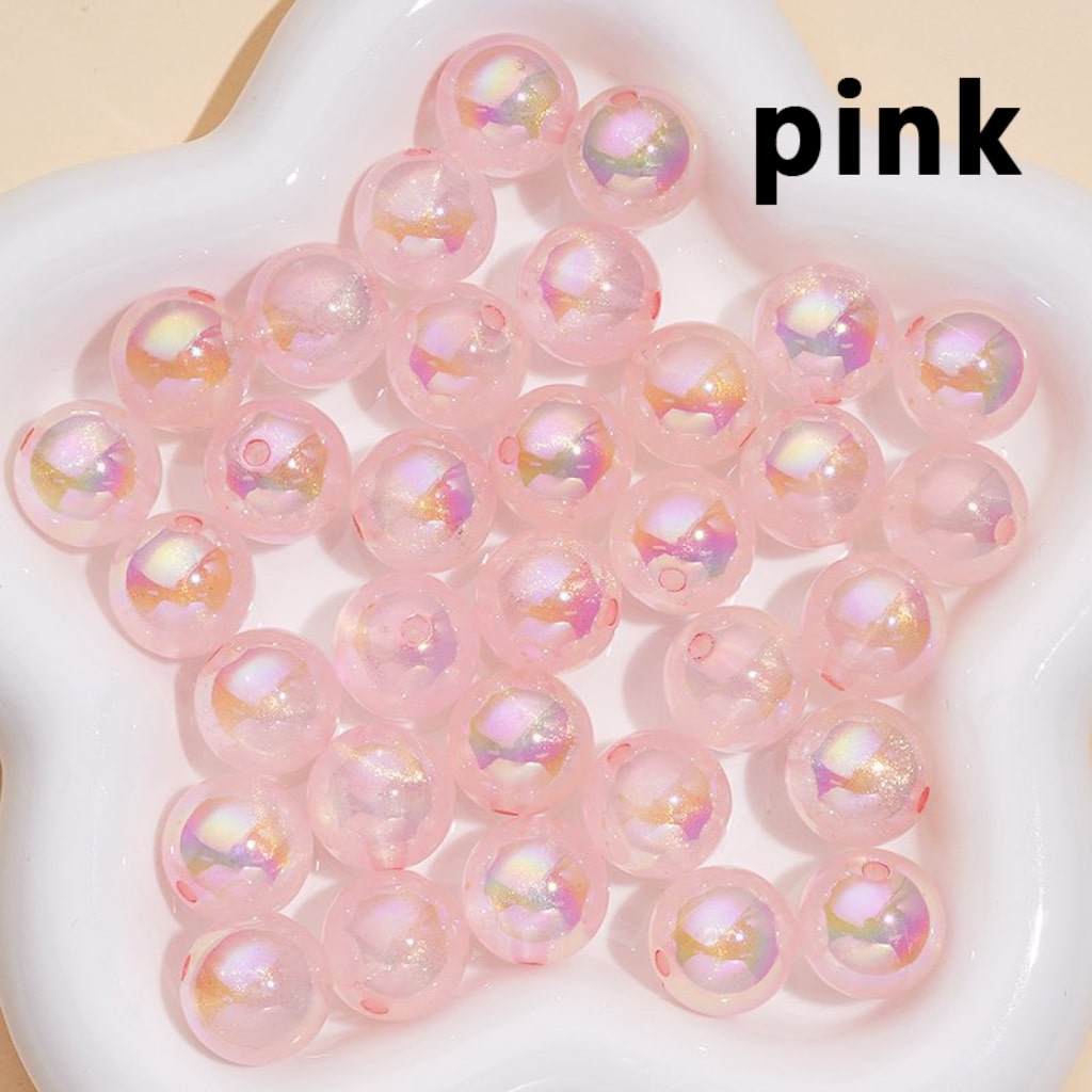 Pink beads with iridescent sheen on a white surface, labeled 'pink'.

