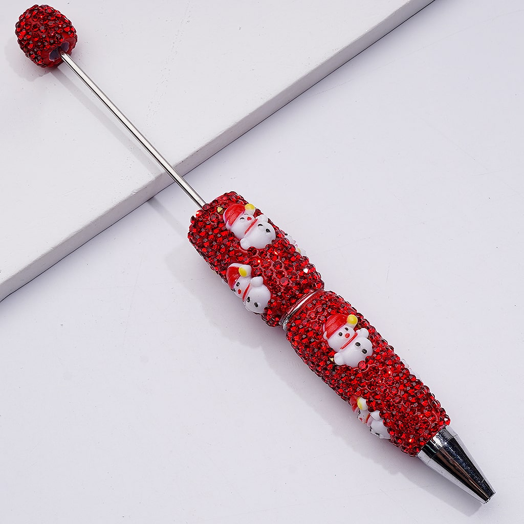 Decorative pen with red embellishments and snowman designs on a white background

