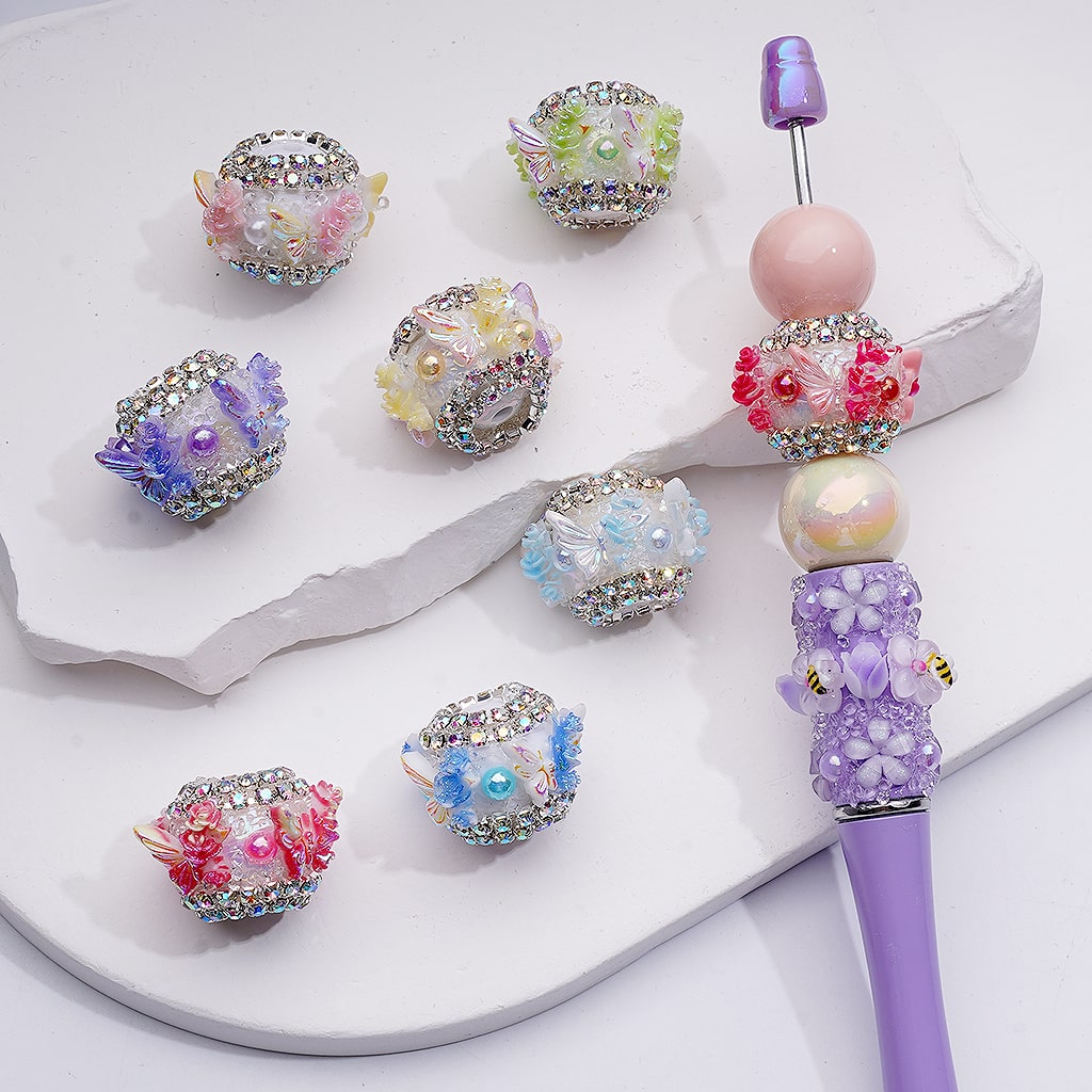 Decorative pen with colorful beads on a white surface

