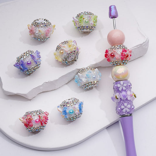 Decorative pen with colorful beads on a white surface

