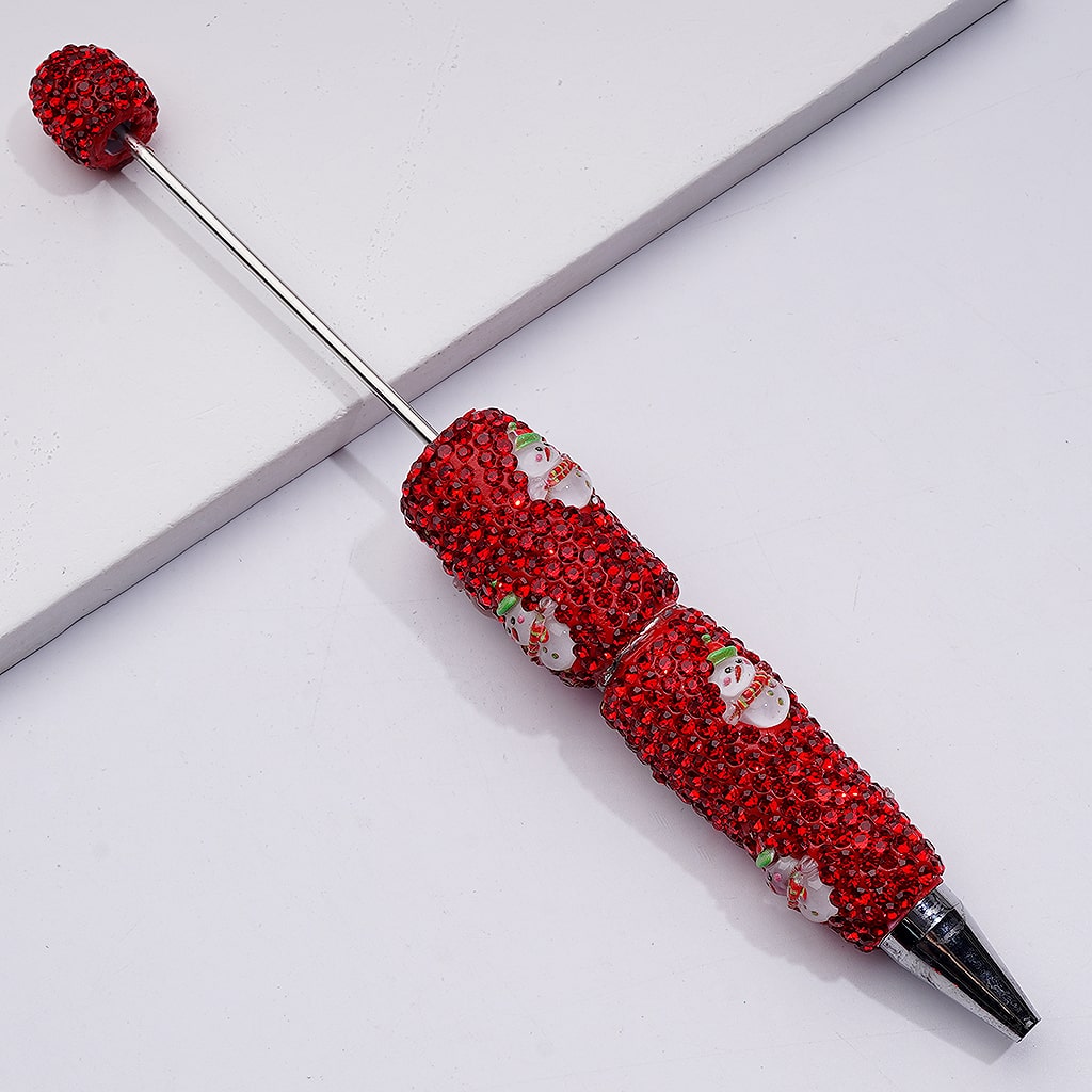 Decorative pen with red gemstone accents on a white background

