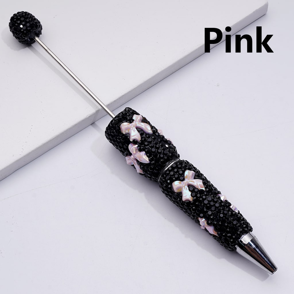 Decorative pen with black beads and pink accents on a white background

