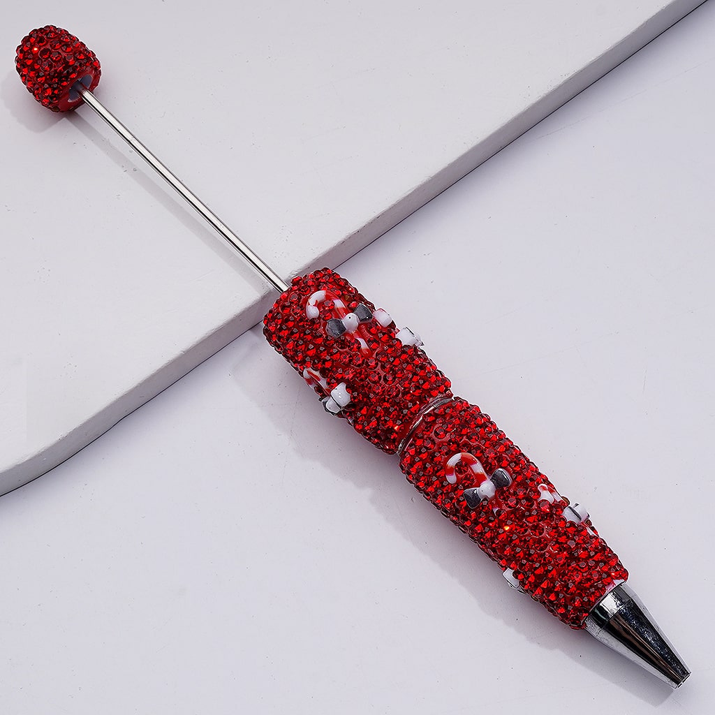 Red rhinestone-studded pen on a white surface

