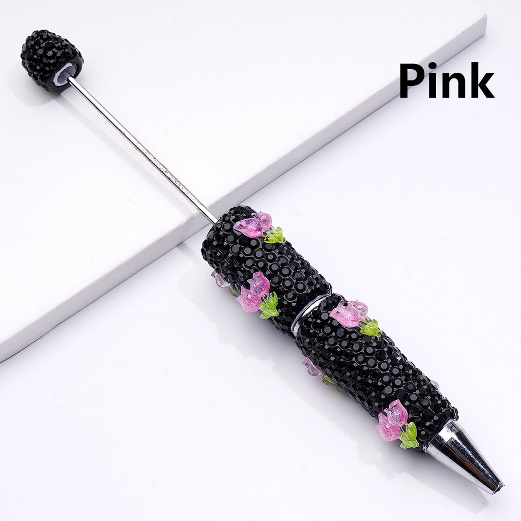 Decorative pen with black beads and pink flowers on a white background

