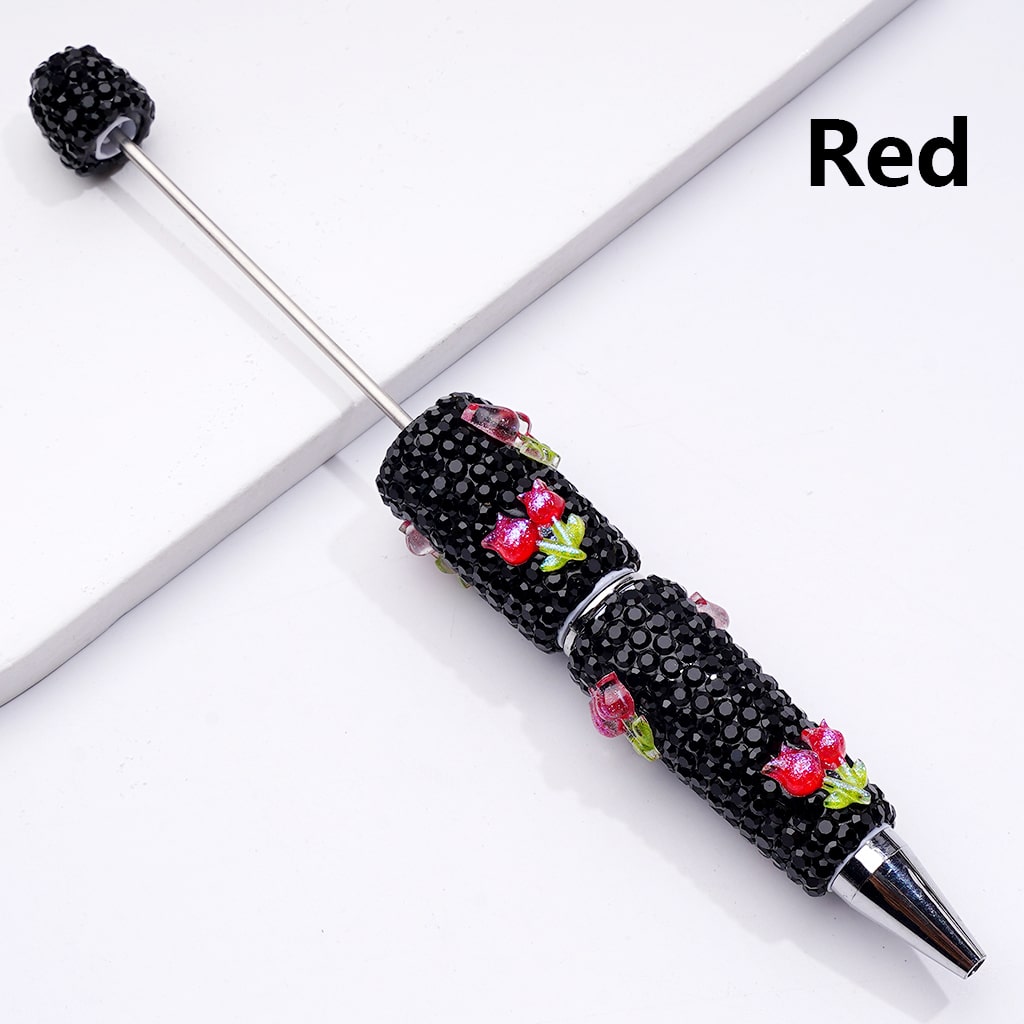 Decorative pen with black beads and red floral accents on a white background

