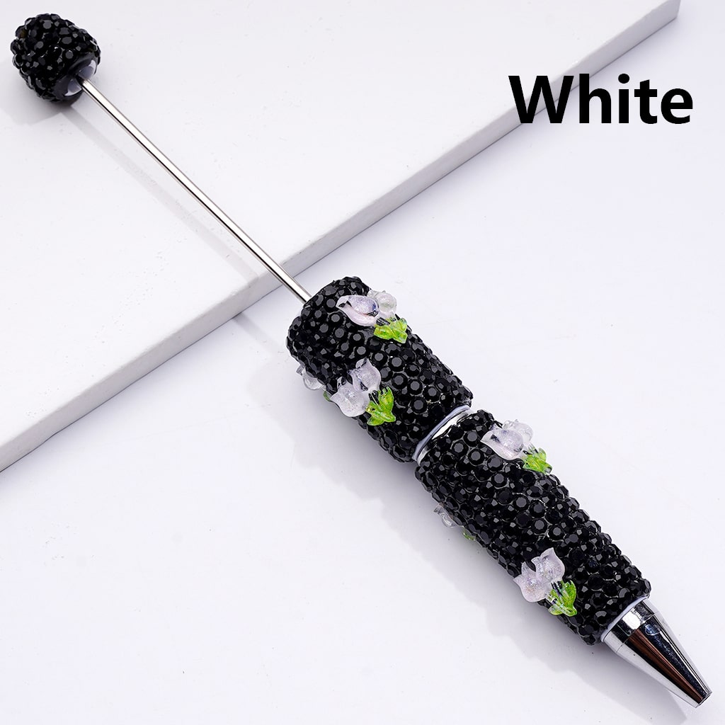 Decorative pen with black beads and floral designs on a white background

