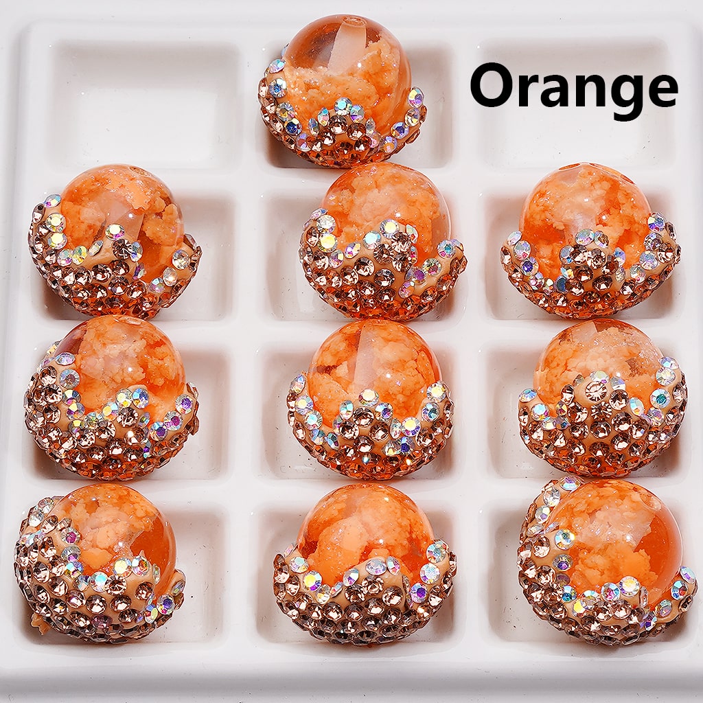 Orange earrings with gemstone accents on a white grid background

