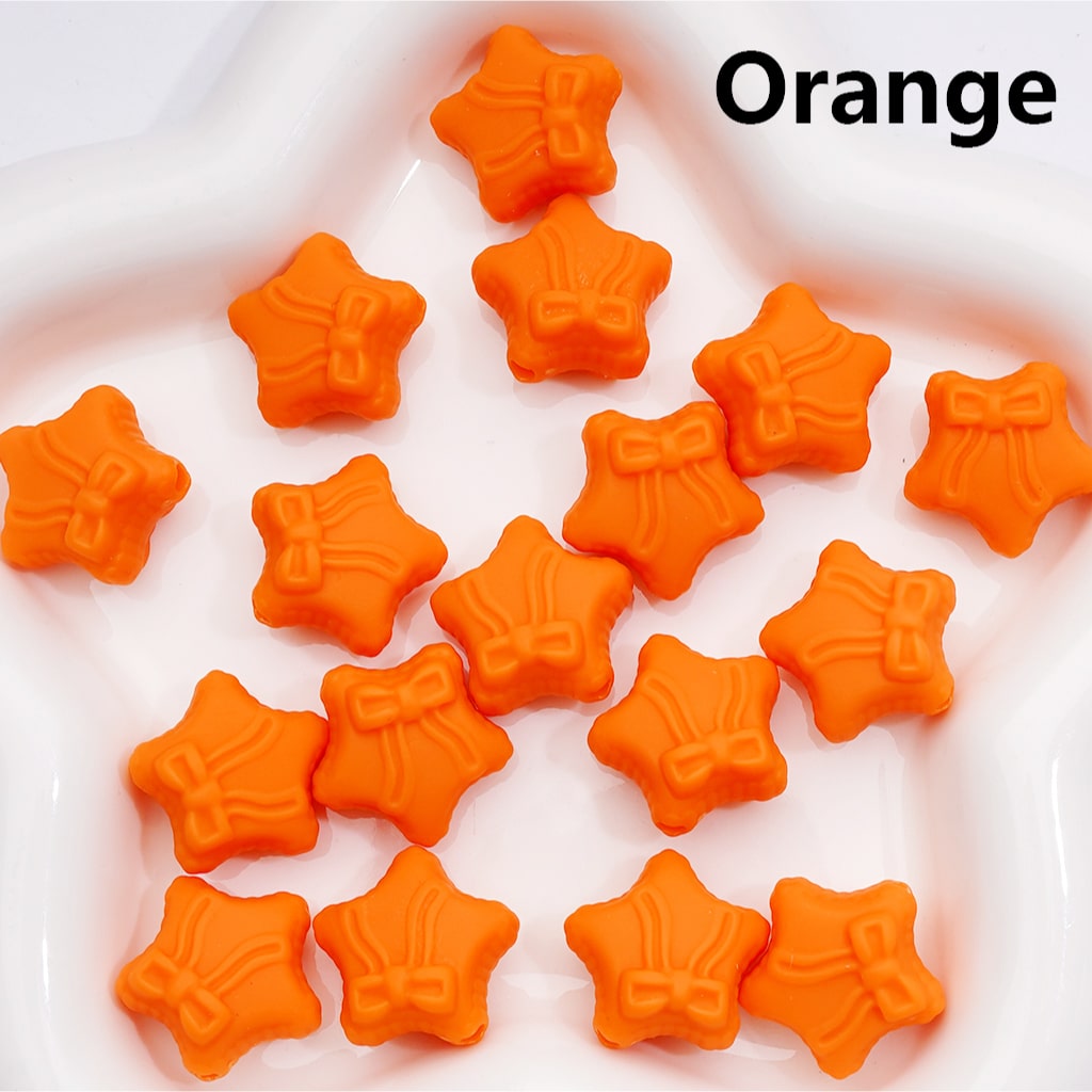 Orange star-shaped candies on a white plate with 'Orange' text above.

