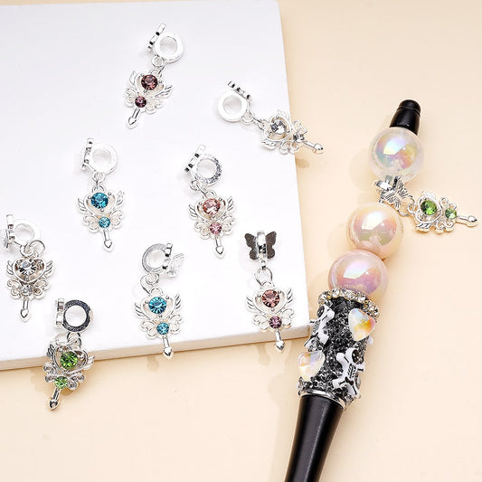 Decorative pen with angel charms on a white background


