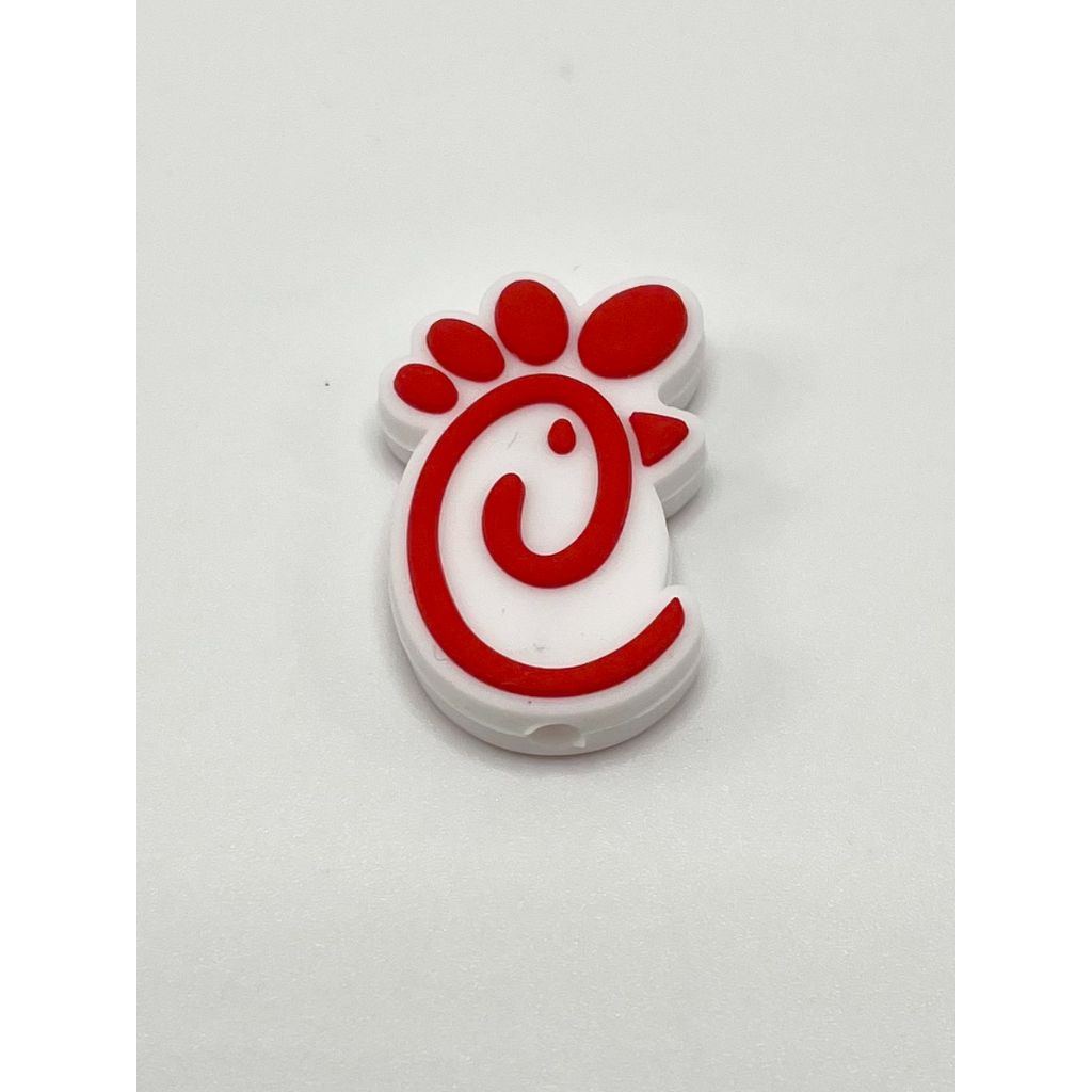 A silicone bead with a red chicken design on a white background.

