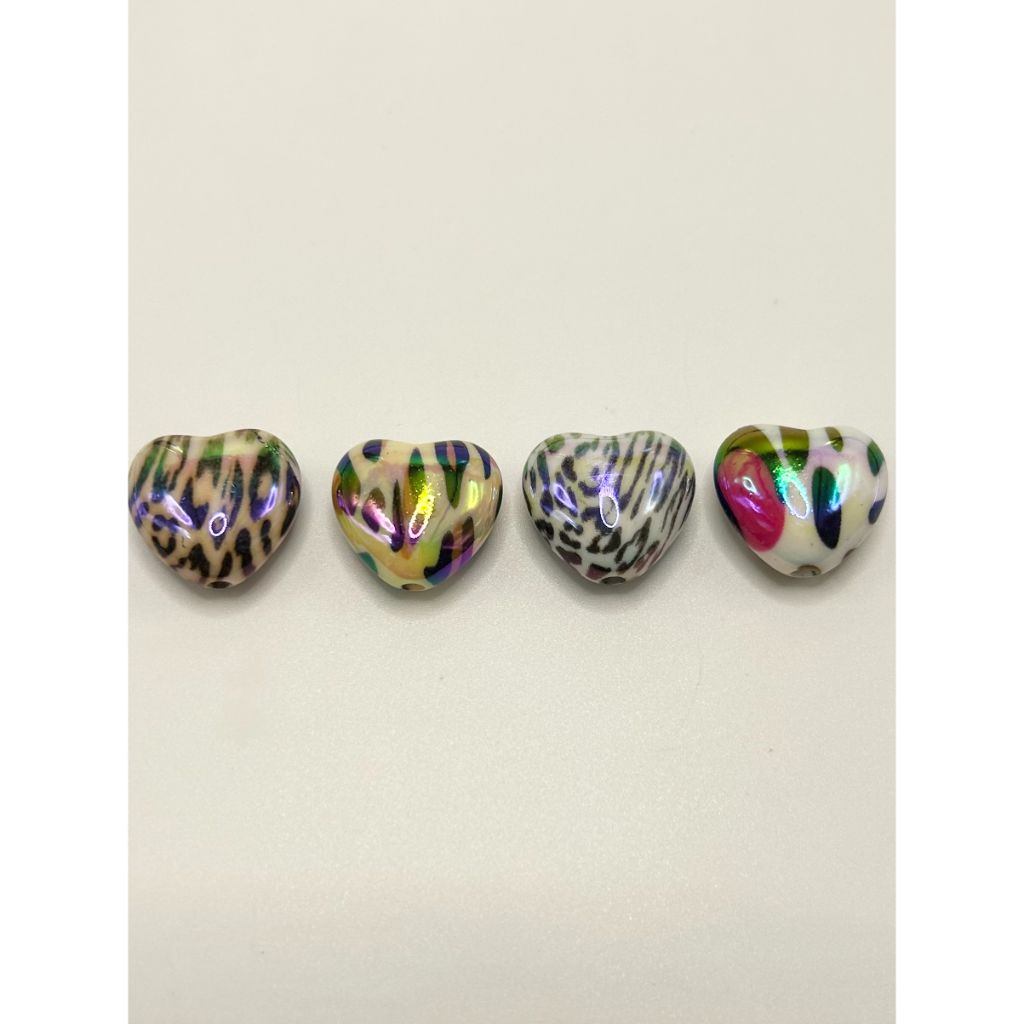 Five heart-shaped objects with leopard print and multicolor patterns on a light gray background

