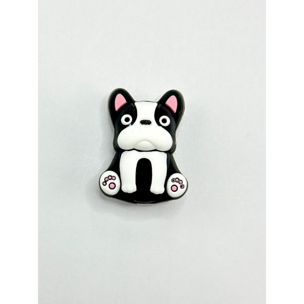 Black and white dog-shaped magnet on a light gray background

