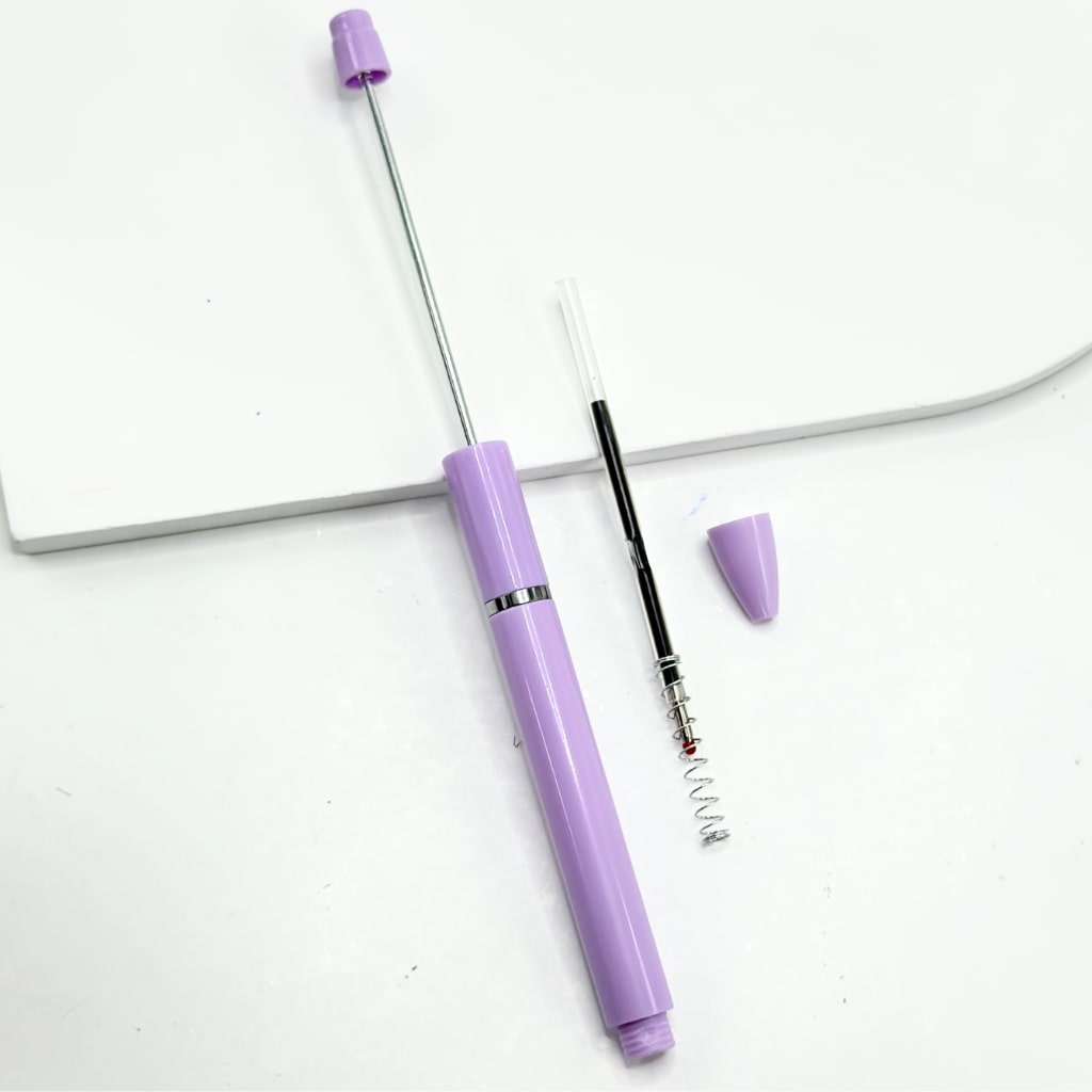 Purple and black telescopic pen on a white background

