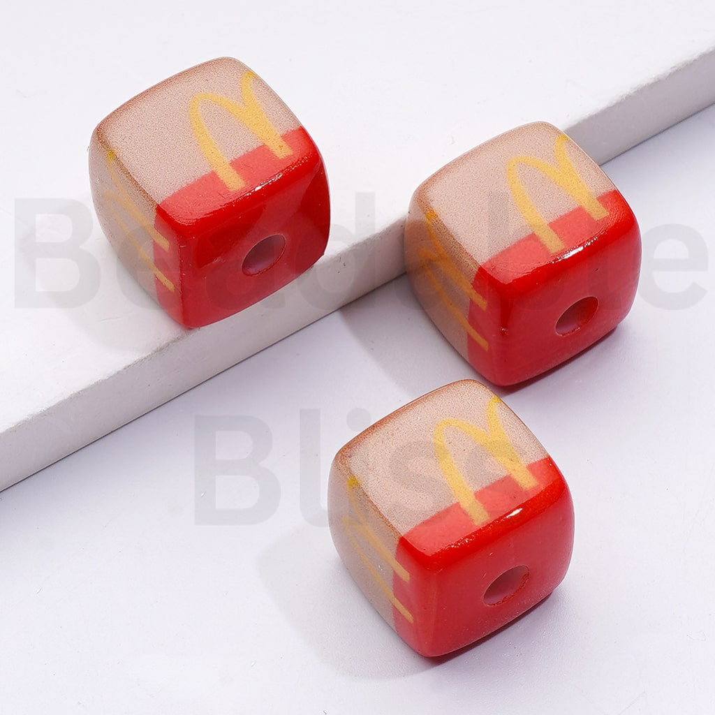 Three cube-shaped pencil sharpeners with red and beige colors on a white background.

