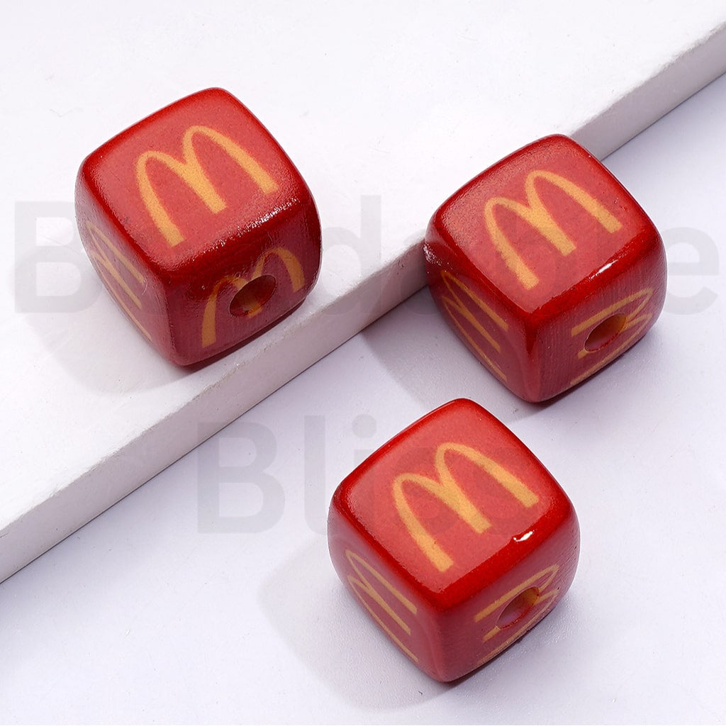 Three red dice with yellow McDonald's logo on a white background


