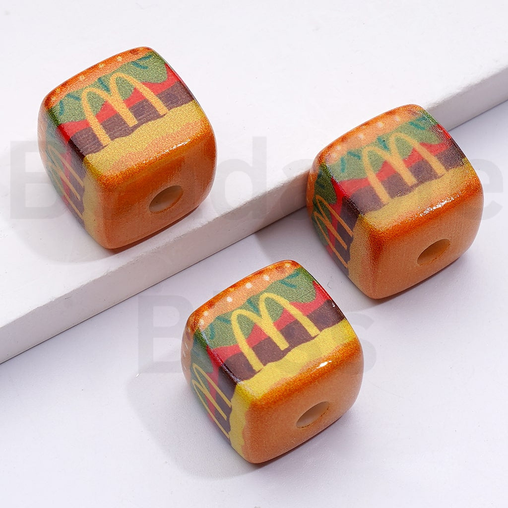 Three wooden dice with McDonald's branding on a white surface

