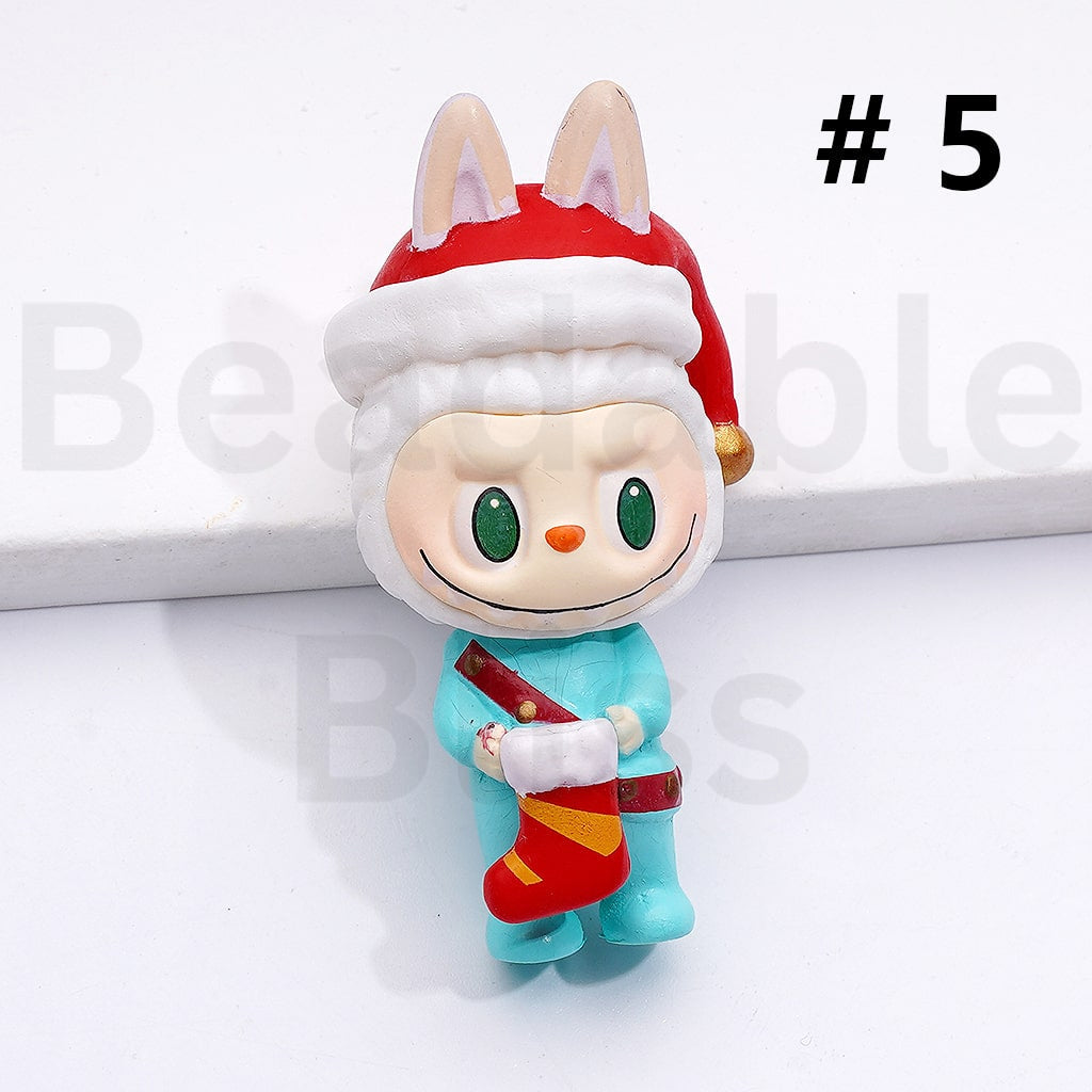 Toy figure of a character wearing a Santa hat and holding a stocking on a white background.

