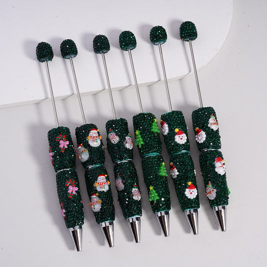 Set of Christmas-themed pens with glittery green accents on a white background

