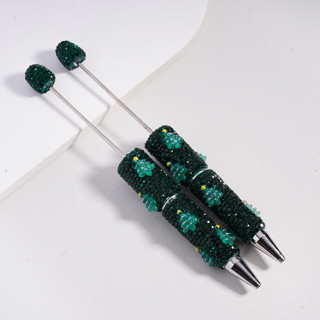 Decorative pen with green bead and snowman design on a white background

