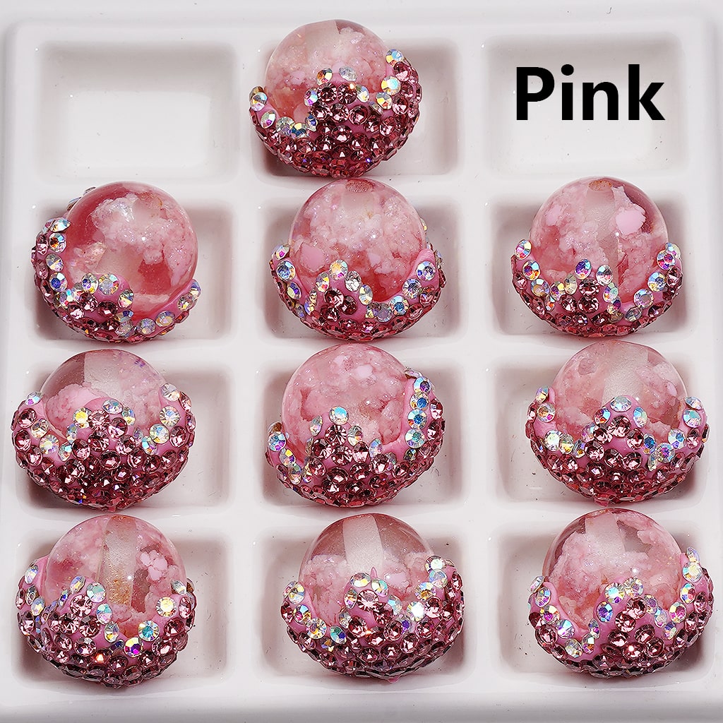 Pink decorative items with gemstone-like embellishments on a white background

