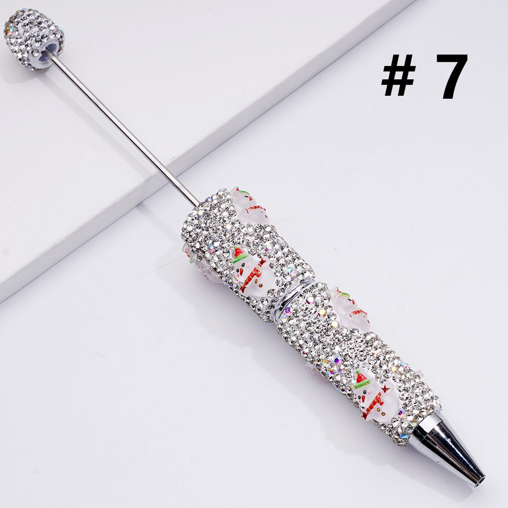 Decorative pen with rhinestone embellishments on a light gray background

