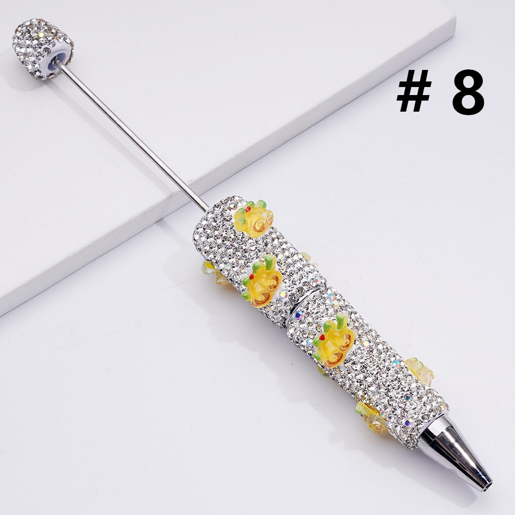 Decorative pen with floral designs and rhinestones on a white background

