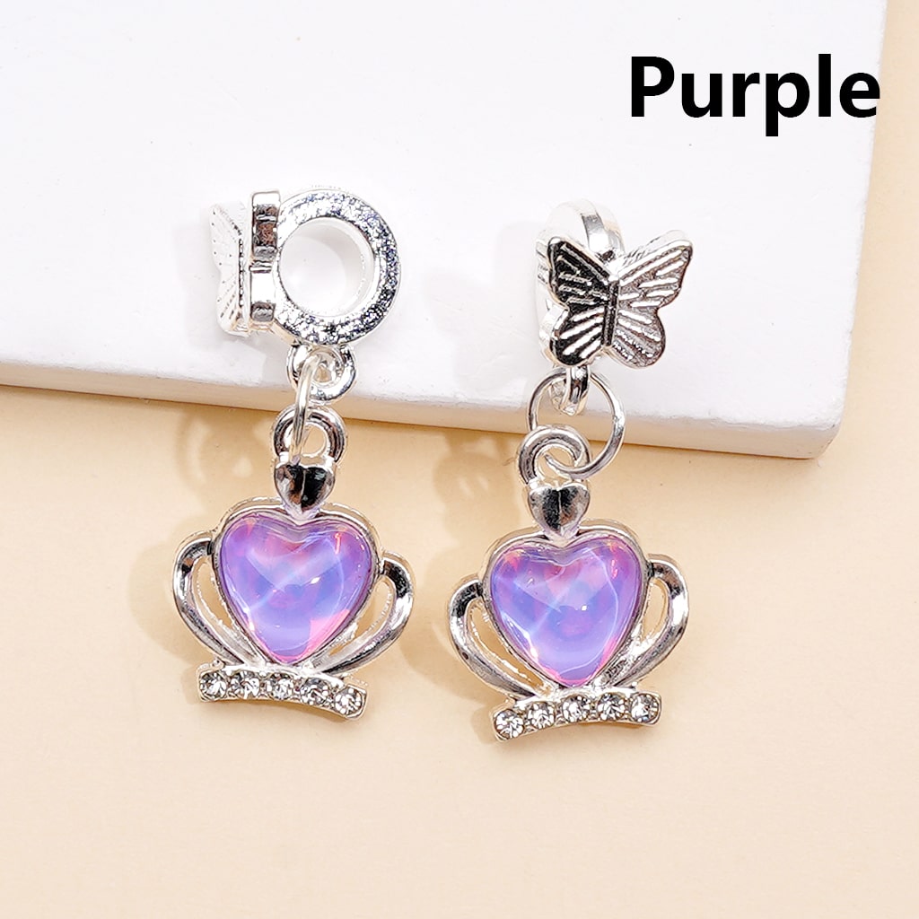 Purple heart-shaped earrings with butterfly charm on a beige background

