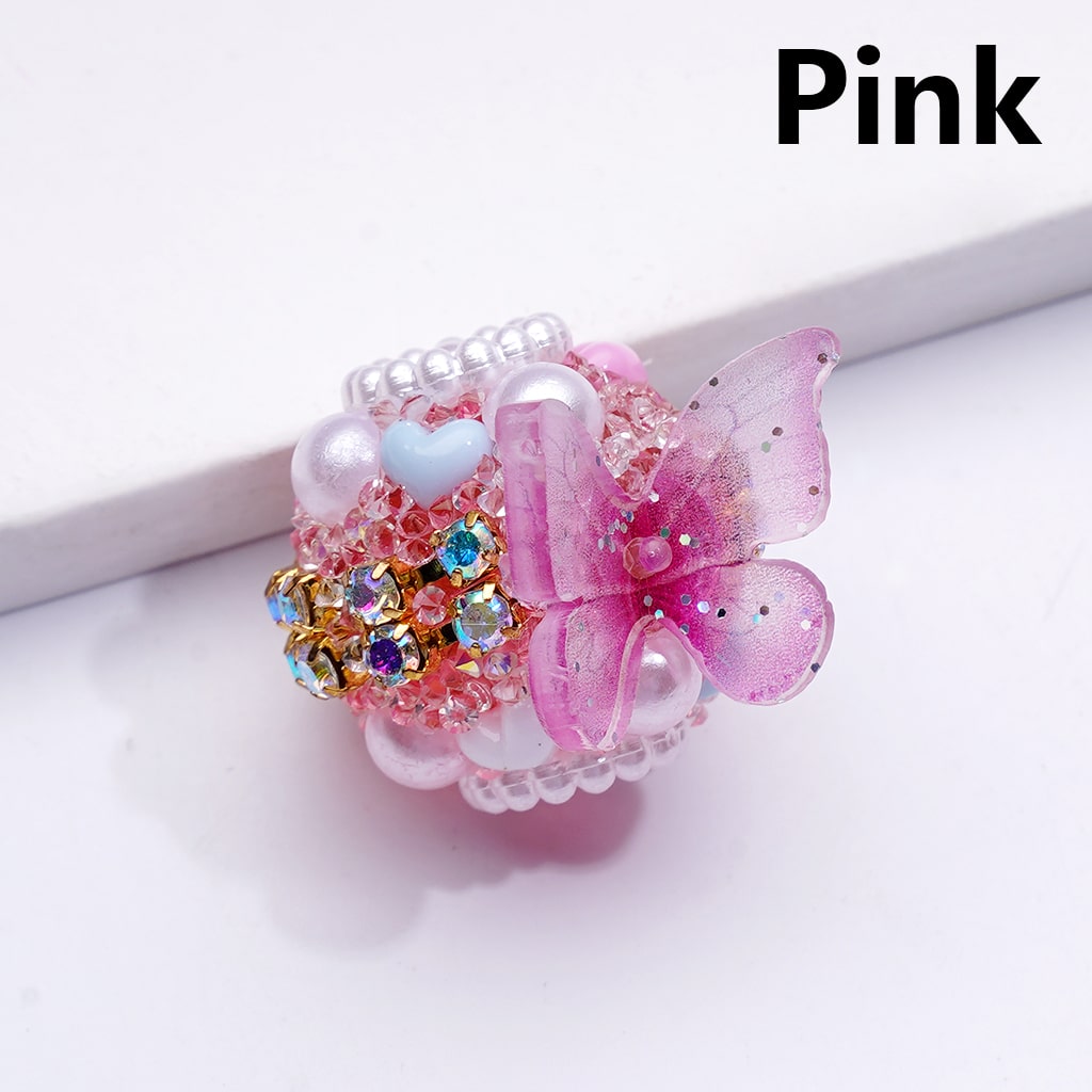 Decorative ring with pink butterfly and colorful stones on a white background

