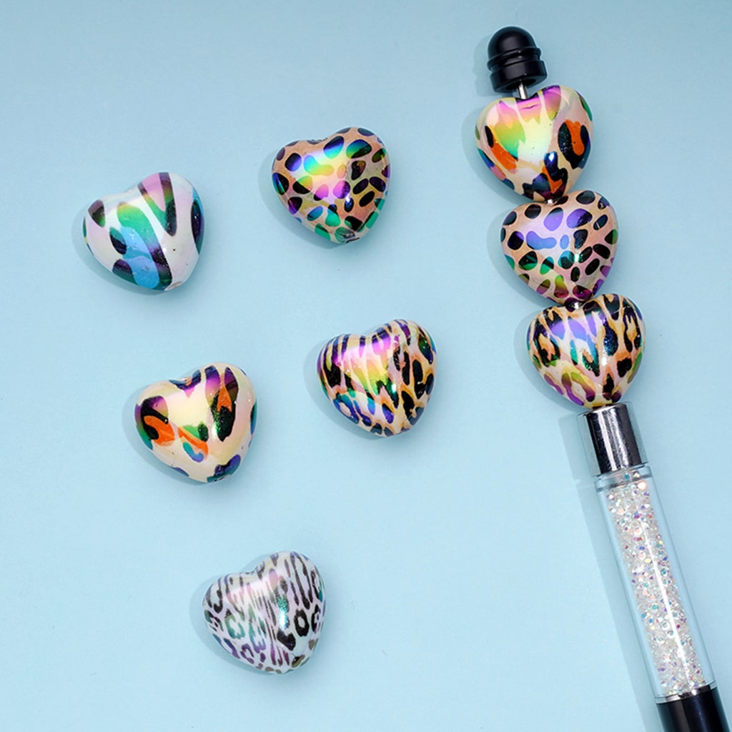 Decorative pen with leopard print heart-shaped accents on a light blue background

