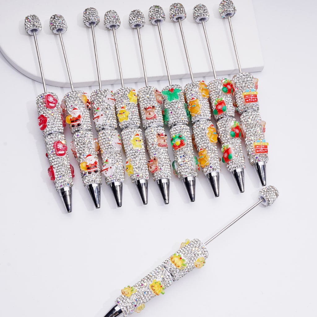 Decorative pens with rhinestone accents and cartoon character designs on a white background

