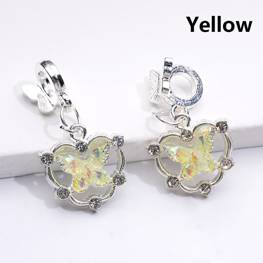 Butterfly-shaped earrings with yellow centers on a white background

