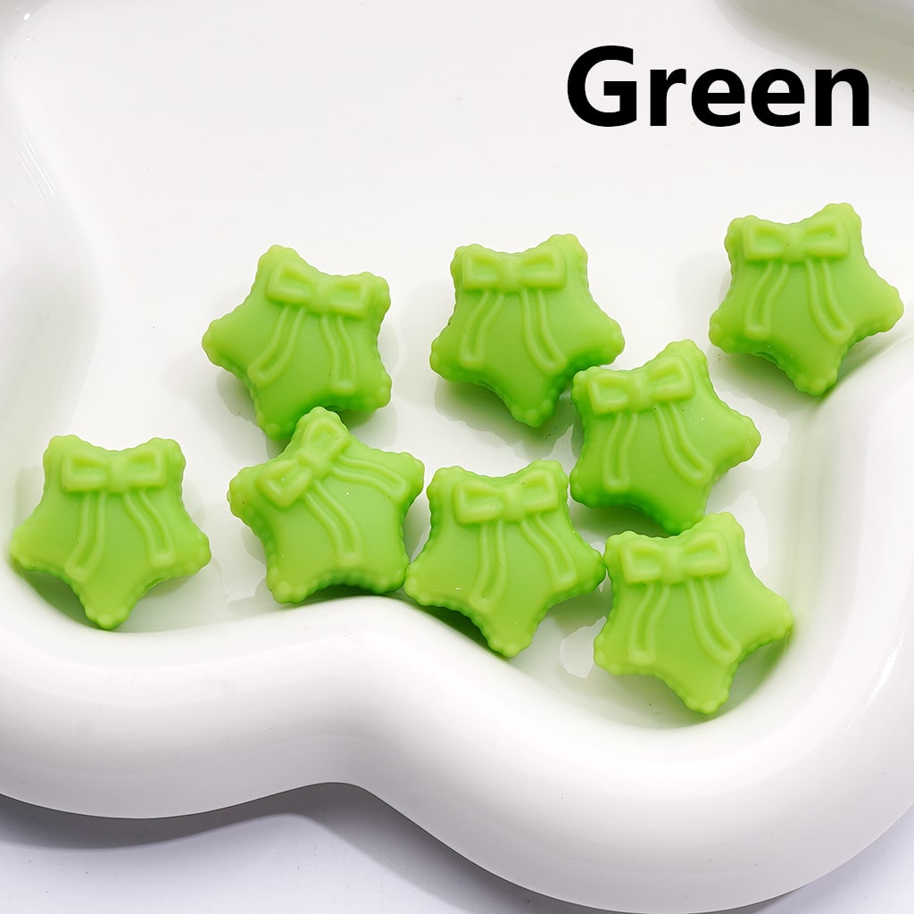Green star-shaped candies with bows on a white plate, labeled 'Green'.

