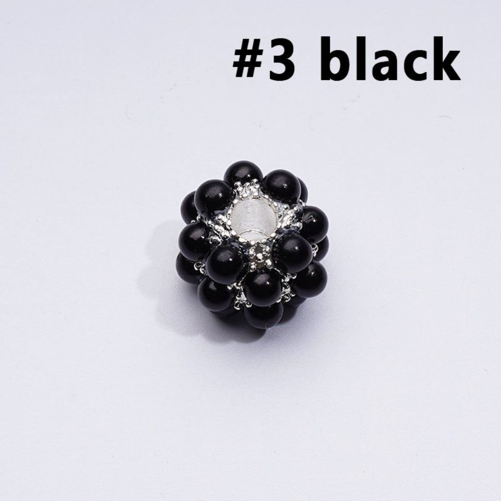 Black beaded ring with silver center on a white background

