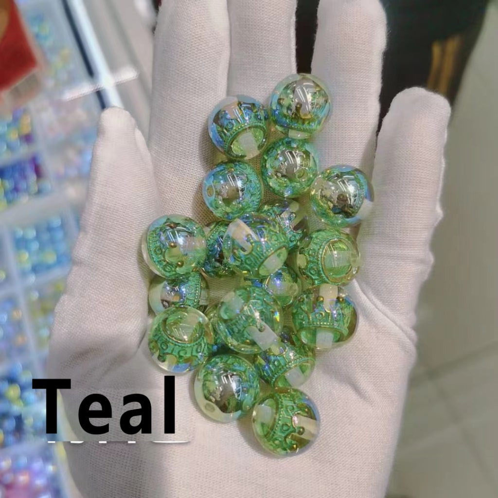 Hand holding teal marbles with a blurred colorful background

