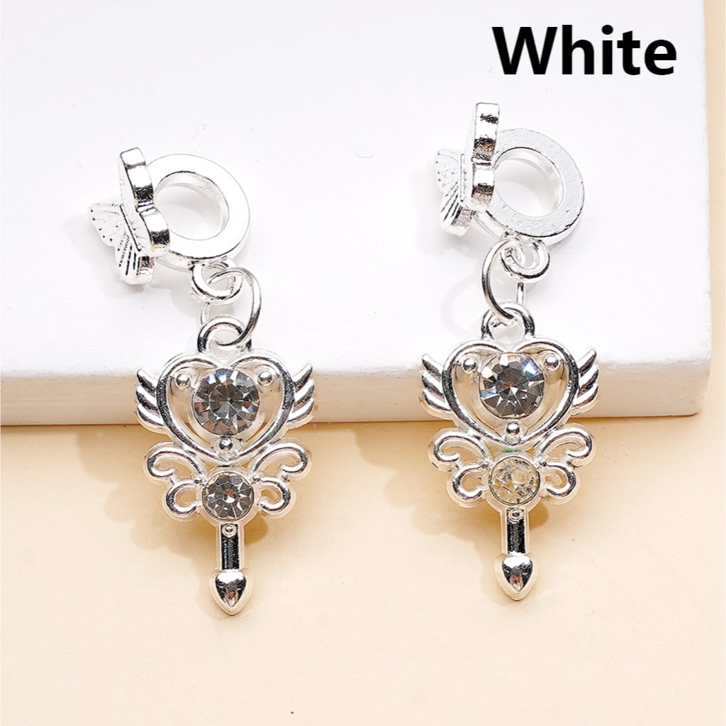 Silver heart-shaped earrings with clear stones on a beige background

