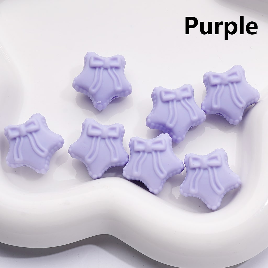 Purple star-shaped objects with bows on a white surface, labeled 'Purple'.

