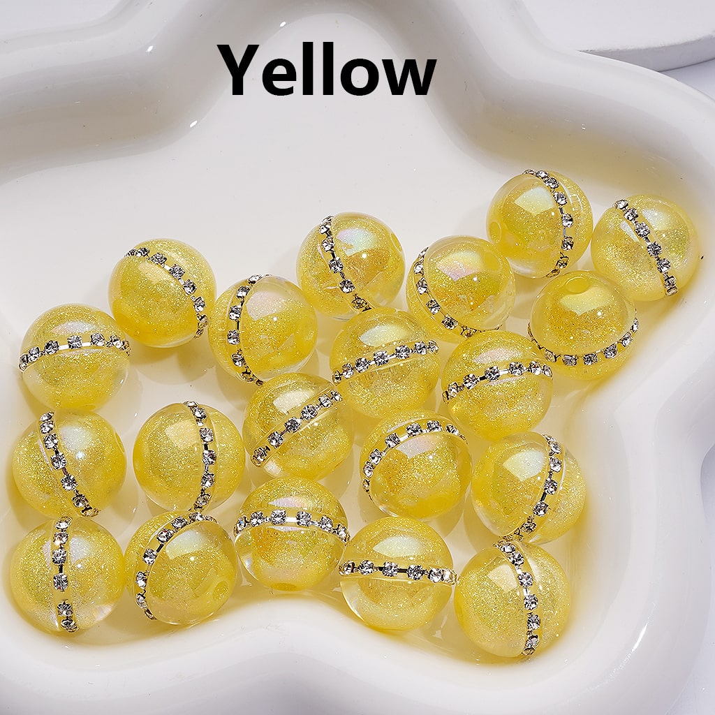 Yellow beads with decorative elements on a white surface

