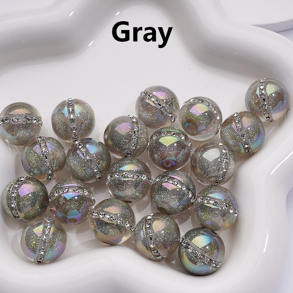 Gray beads with metallic accents on a white dish

