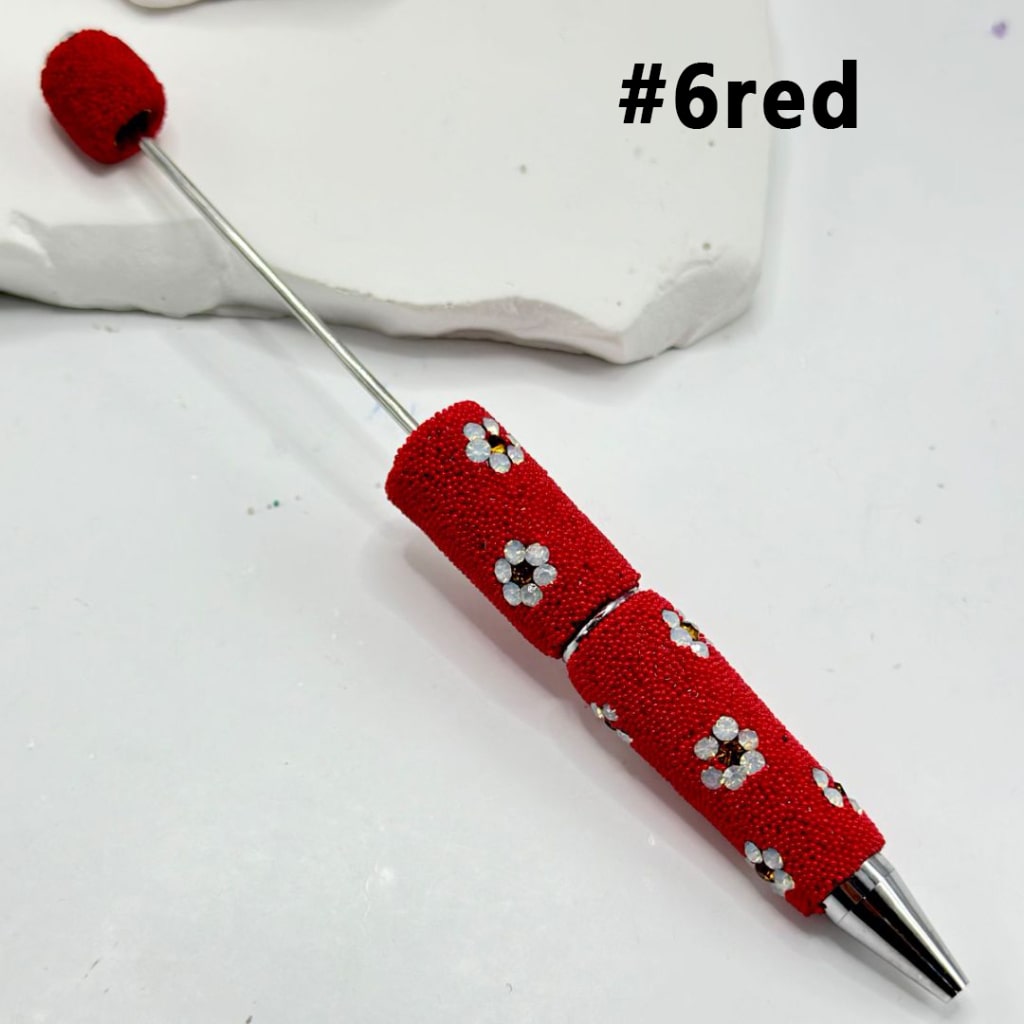 Red textured pen with silver accents on a white background

