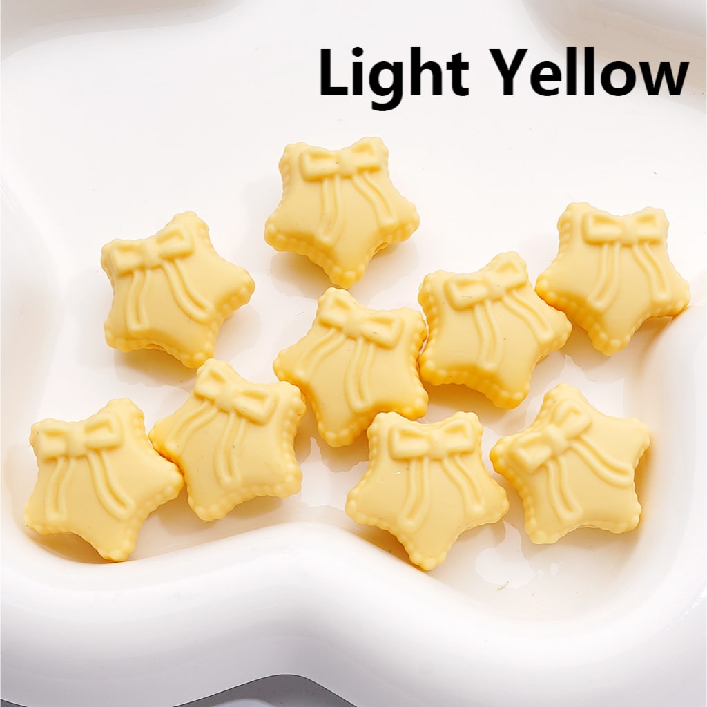 Light yellow star-shaped cookies with bows on a white surface, labeled 'Light Yellow'.


