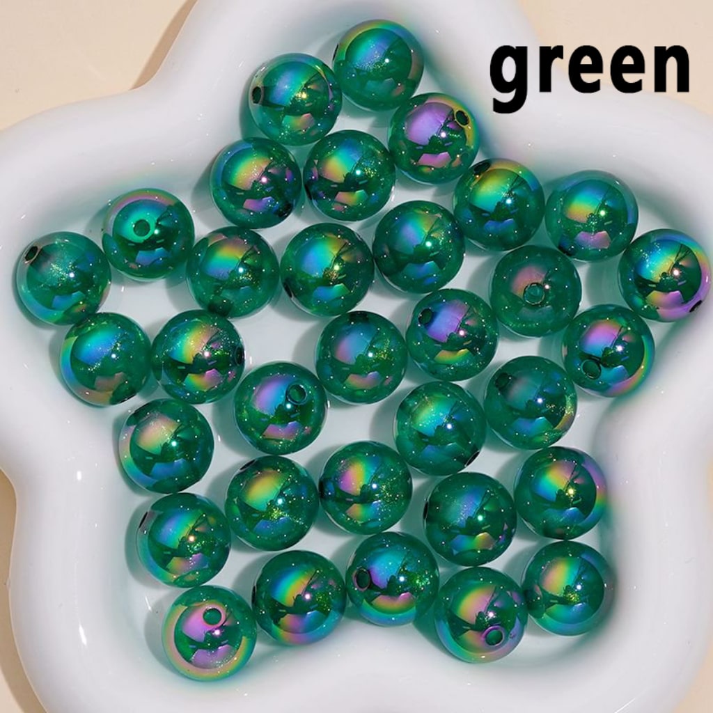 Green beads with iridescent finish on a white dish

