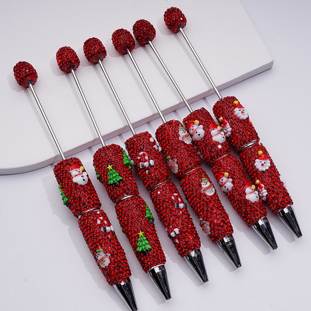 Set of red Christmas-themed pens with silver accents on a white background

