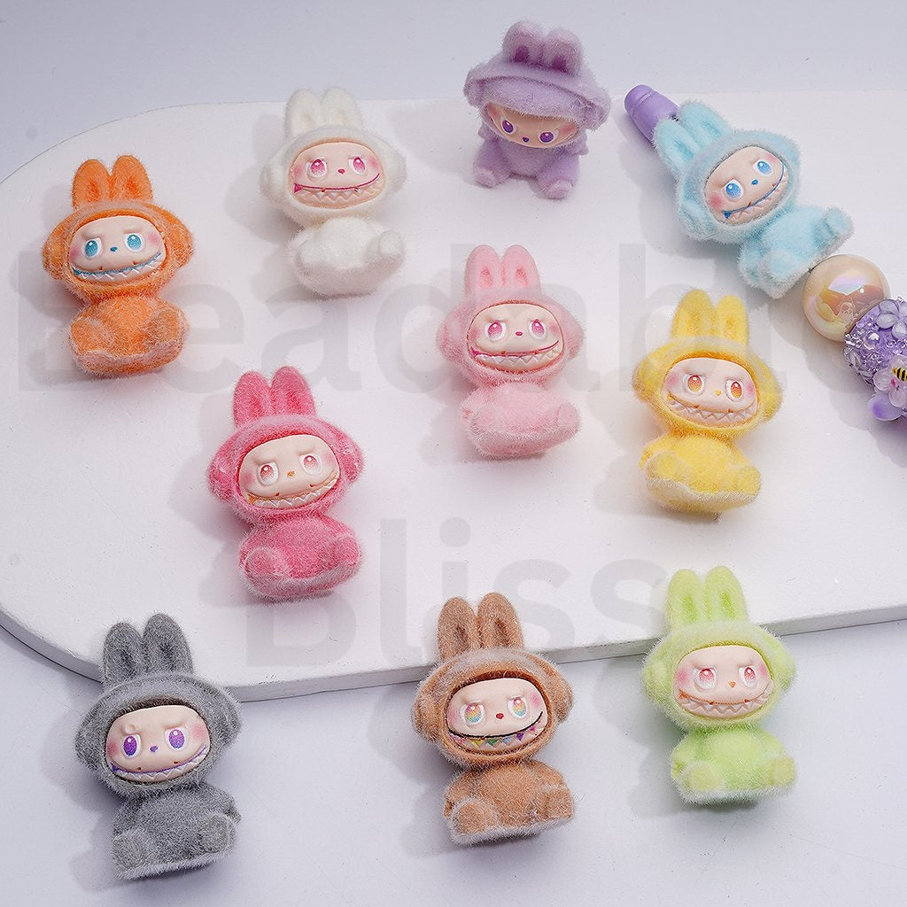 Colorful cartoon character figurines on a white surface with 'beadablebliss' branding.

